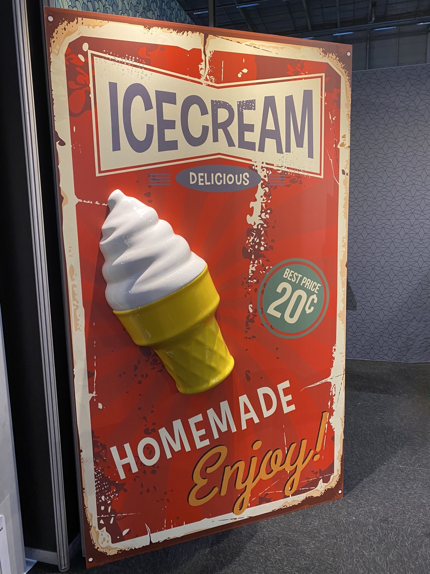 Printed sign with 3D ice cream cone on red vintage-style background, promoting homemade ice cream