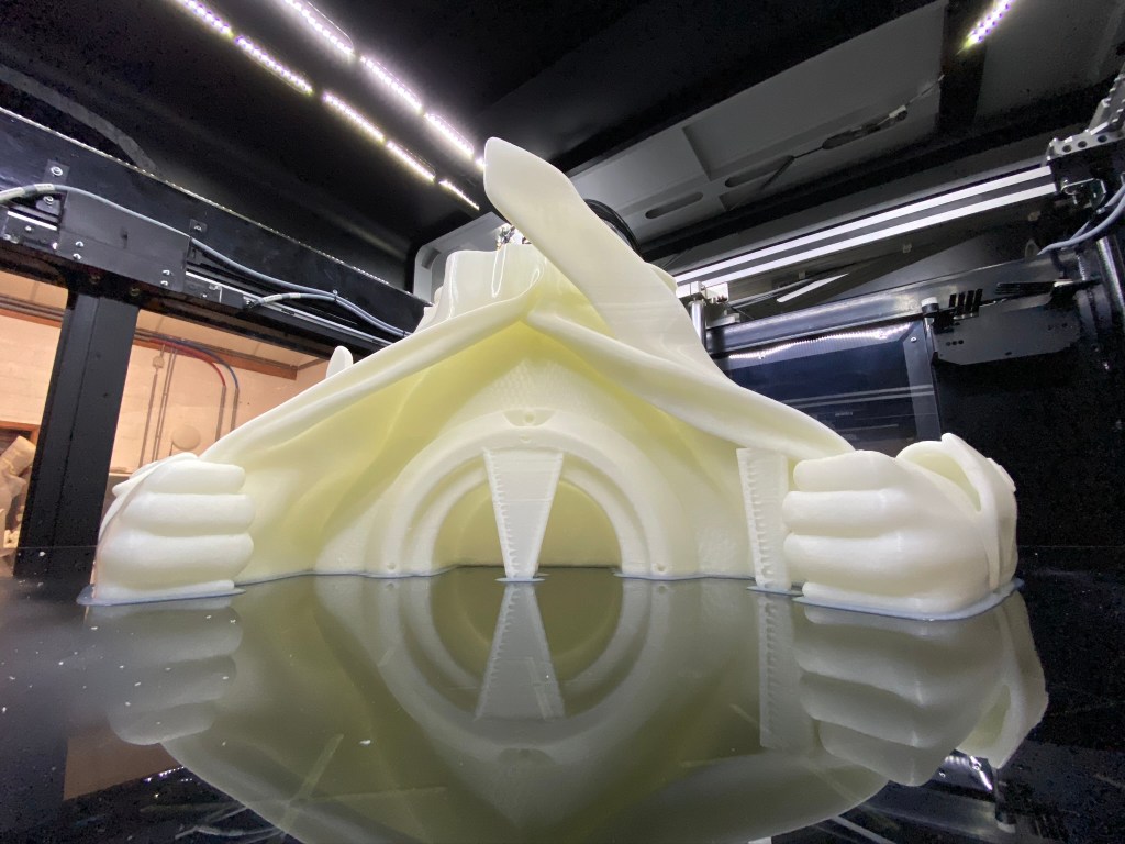 Partial 3D print in progress of a large-scale sculpture, showcasing intricate details and structure