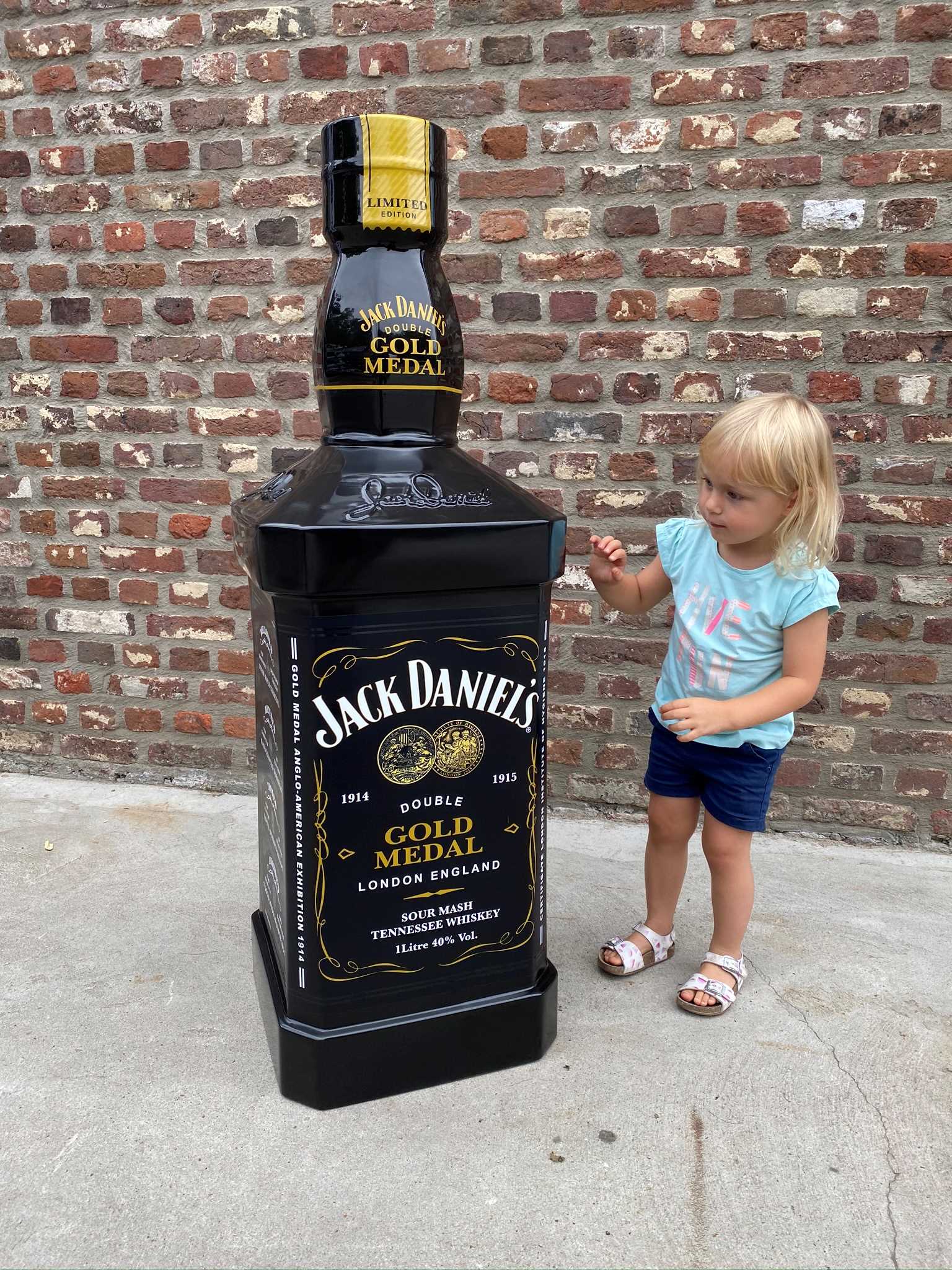 Large 3D-printed Jack Daniel's Gold Medal whiskey bottle with a child for scale