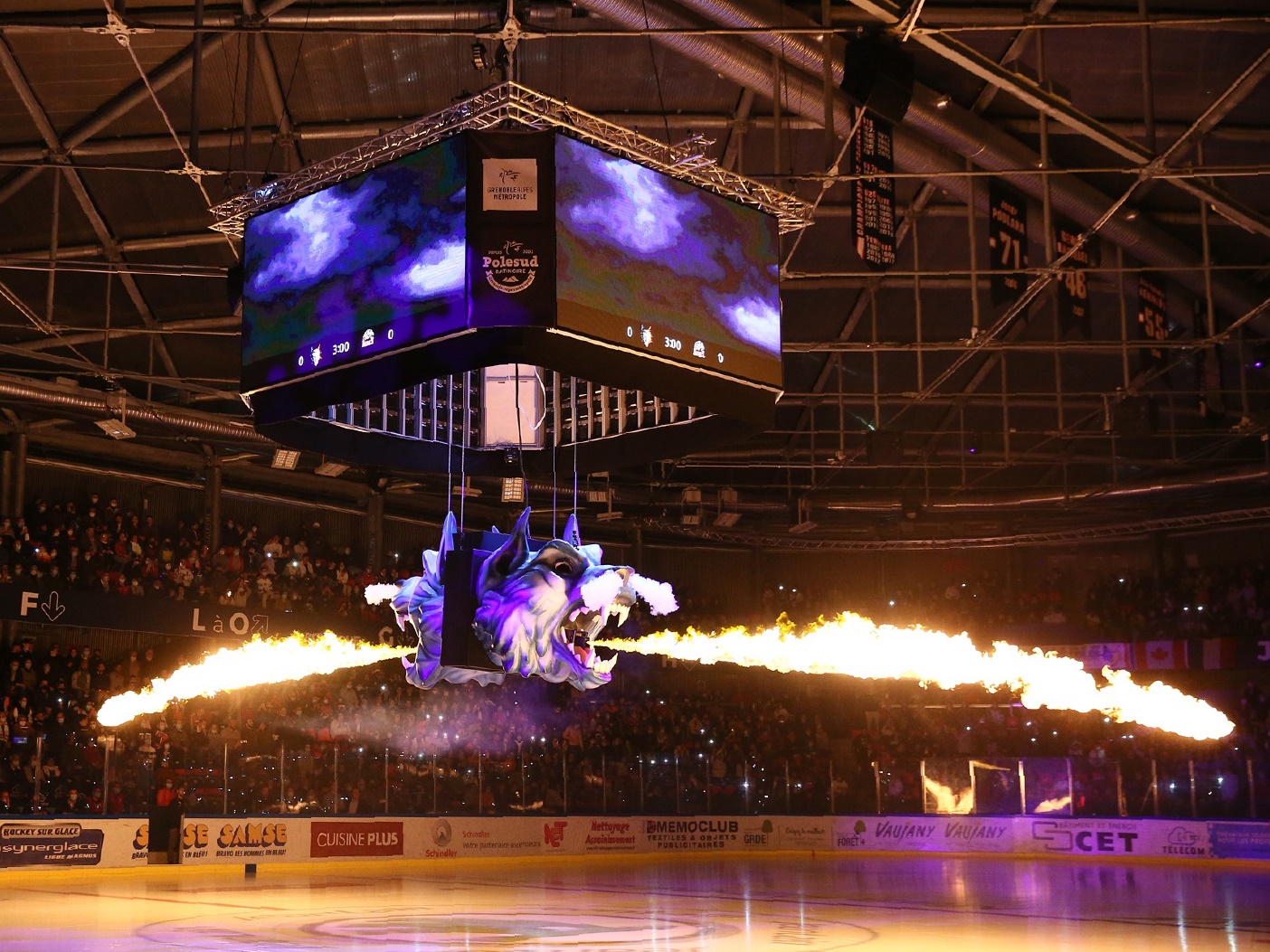 wolf sculpture suspended in ice ring with dramatic fire and laser light effects during game breaks