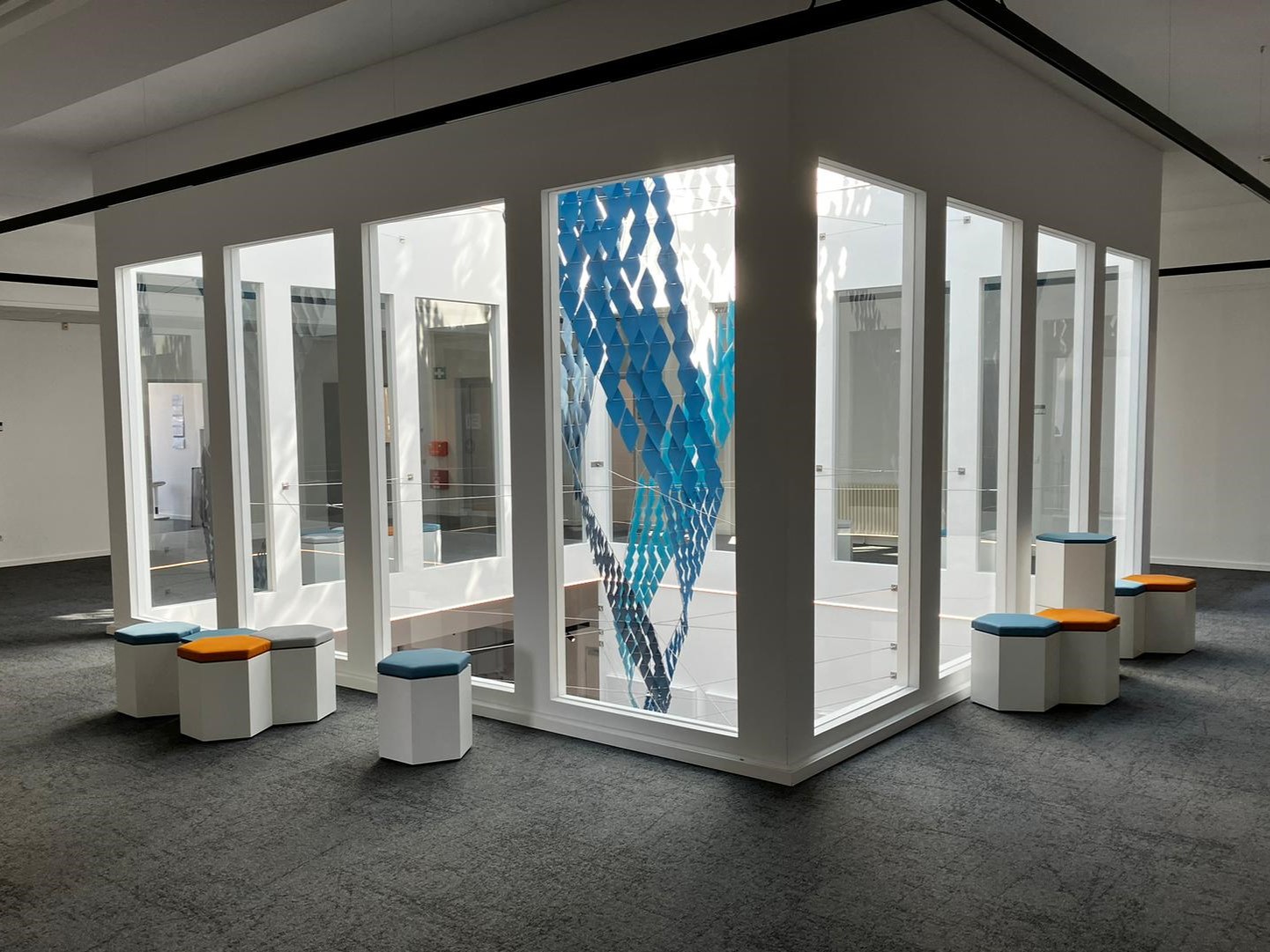 Vortex sculpture installation at Solenis sales headquarters atrium in Mönchengladbach, designed by Twan Kerckhofs, featuring paper leaflets in blue hues.